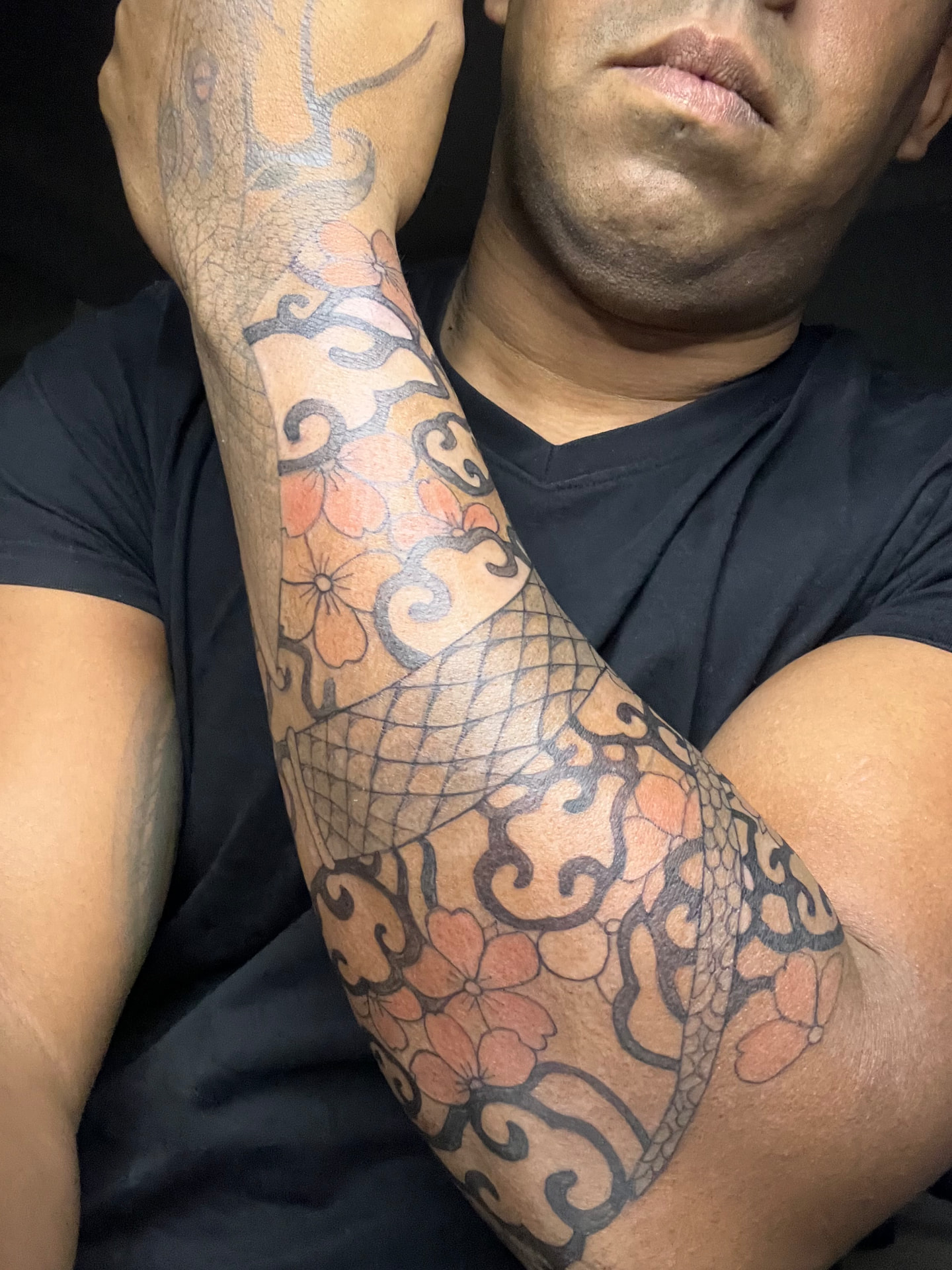 Tatuaje de flores y motivos ornamentales en un brazo